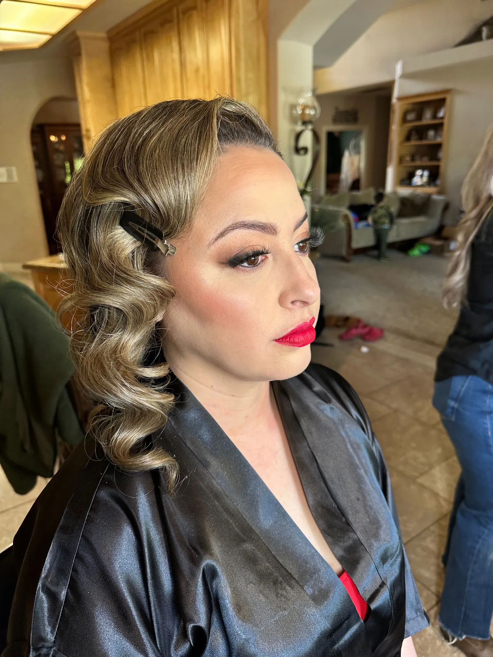 A client with vintage-set waves and a bold red lip, photographed on location on the morning of the event